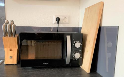 a black microwave sitting on top of a counter at Fe Wo Brunnen - 120 qm - ruhige Lage - viel Natur- komfortabel - grosser Balkon und Garten - 3D Rundgang verfügbar in Memmingen