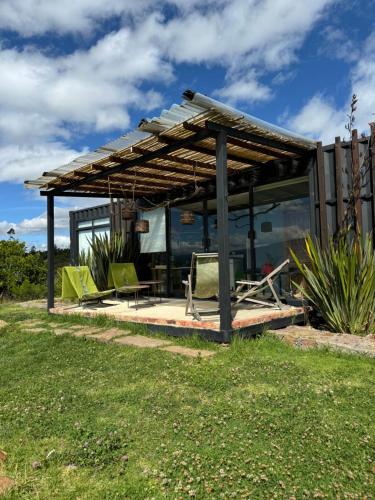a pavilion with chairs and a table in a yard at Minicasas La Villa in Santa Sofía
