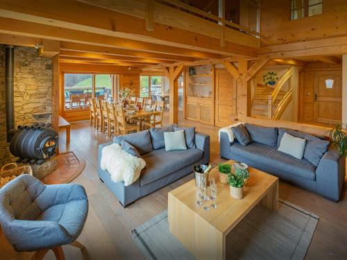 un salon avec des canapés bleus et une table dans l'établissement Lodge La Source - OVO Network, à Les Clefs