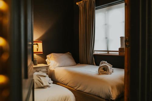 a hotel room with two beds and a window at Le Petit Chateau & William de Percy in Otterburn