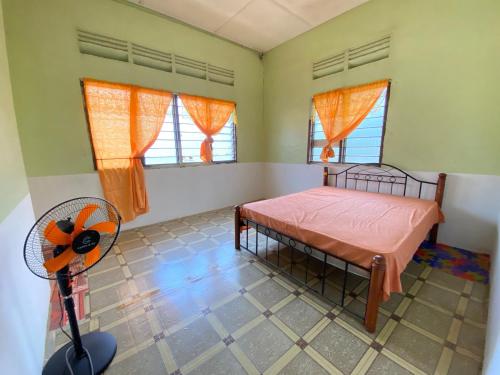 a bedroom with a bed and a fan at MY Gunung Homestay Vintage in Bachok