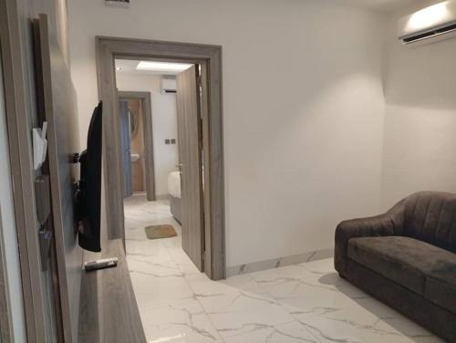 a living room with a couch and a door at Calico Hotel and Suites, Abuja in Gwarinpa