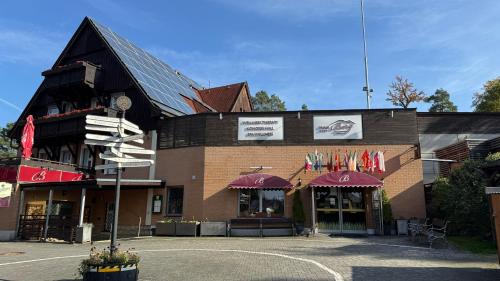 a large brick building with flags in front of it at Hotel Berg in Staré Splavy