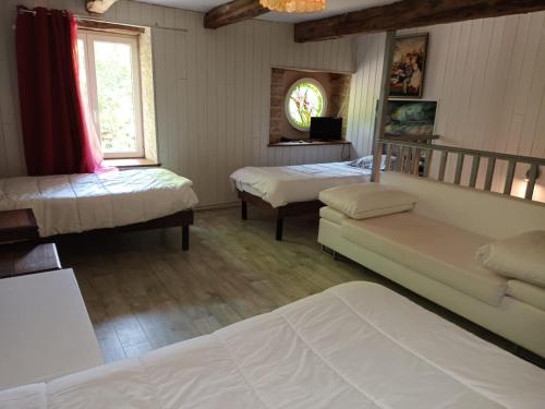 - une chambre avec 2 lits, un canapé et une télévision dans l'établissement Domaine de Juliette, à Confracourt