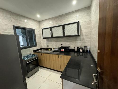 una cucina con un piano di lavoro nero e una stufa di Résidence Elyone 3 pièces a Abidjan