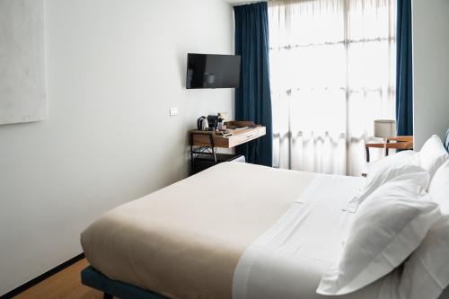 a bedroom with a white bed and a window at Club64 in Andria