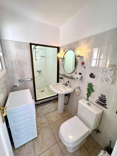 a bathroom with a toilet and a sink and a mirror at Villa Casa Lilo, en jardin grande,con una gran piscina, con pérgola y barbacoa in Arona