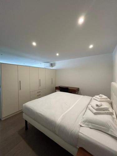 a bedroom with a large bed and white cabinets at Moderno appartamento a Tenero in Tenero