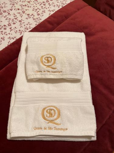 ペーゾ・ダ・レーグアにあるQuinta de São Domingos houseのベッドの上に座るタオル2枚