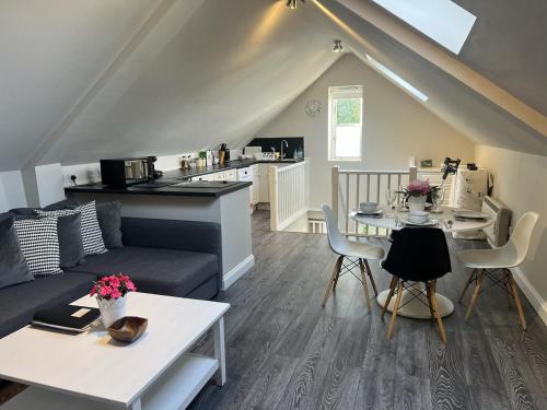 a living room with a couch and a table at Bright, Restful Coach House in Central Sevenoaks in Sevenoaks