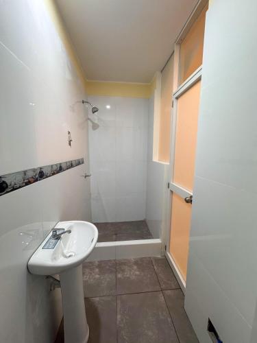 a white bathroom with a sink and a shower at Hotel Krammer en San Ramón, Selva Central in San Ramón