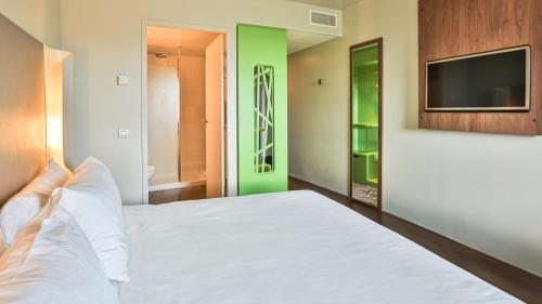 a bedroom with a white bed and a television at Campanile La Roche Sur Yon Centre Gare in La Roche-sur-Yon