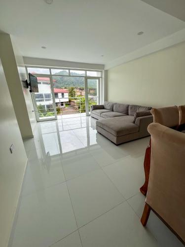 a living room with a couch and a large window at Hotel Krammer en San Ramón, Selva Central in San Ramón