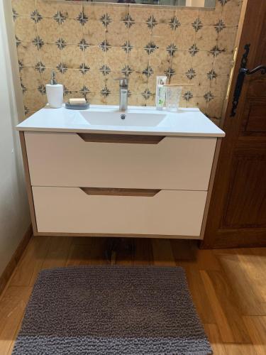 une salle de bain avec un lavabo blanc et un miroir dans l'établissement Les Frigoules des Hauts de Fabiargues, à Saint-Ambroix