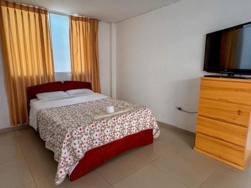 a bedroom with a bed and a flat screen tv at Hotel Krammer en San Ramón, Selva Central in San Ramón