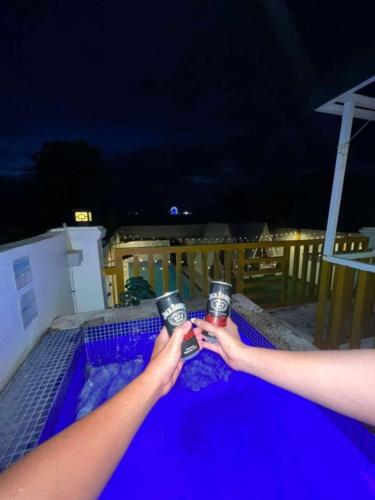 two people are holding up drinks in their hands at Couple - Private Jacuzzi Pool in Mabalacat