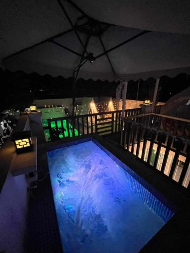 a swimming pool on top of a balcony at night at Couple - Private Jacuzzi Pool in Mabalacat