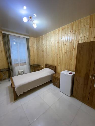 a bedroom with a bed and a small refrigerator at Black Sea Pearl in Makhinjauri