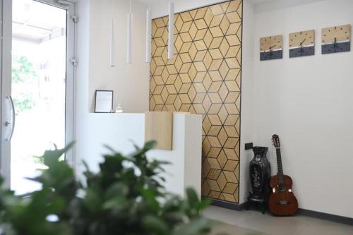 a living room with a guitar next to a wall at Benefice Hotel Yerevan-通緝 in Yerevan