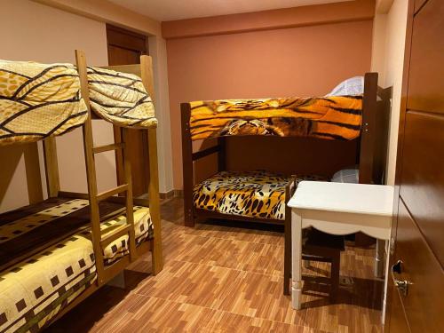 a room with two bunk beds and a table at Aventura Chachapoyas Backpackers in Chachapoyas