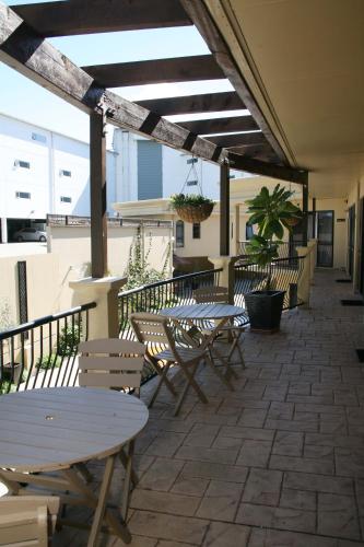 a group of tables and chairs on a patio at Tuscany Villas Whakatane in Whakatane
