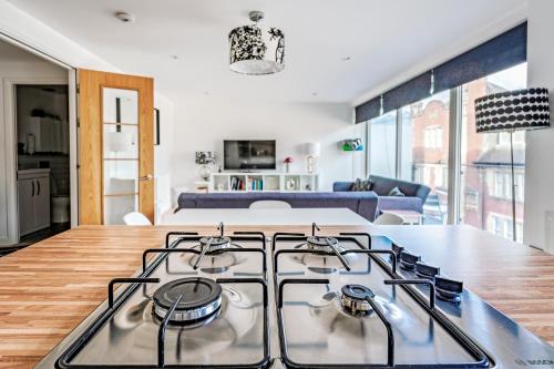 a kitchen and living room with a stove top at Glasgow City Flats in Glasgow