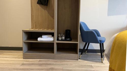 a book shelf next to a blue chair in a room at Marine Hotel Ballycastle in Ballycastle