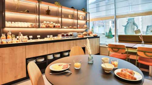 a restaurant with a table with two plates of food at Campanile La Roche Sur Yon Centre Gare in La Roche-sur-Yon