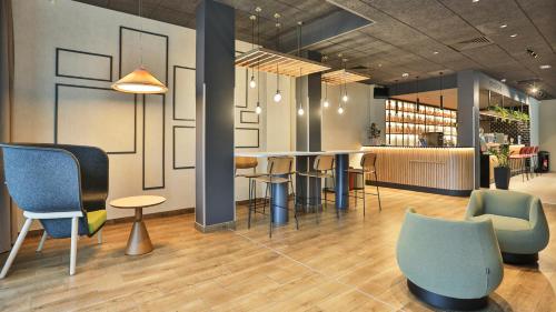 a lobby with a bar with chairs and tables at Campanile La Roche Sur Yon Centre Gare in La Roche-sur-Yon