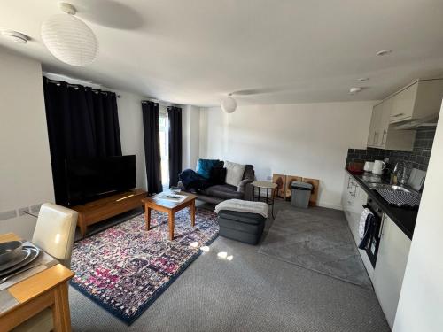 a living room with a couch and a tv at 4 Town centre, Free off road parking, entire flat in Huntingdon