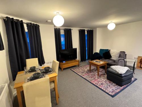a living room with a couch and a table and a television at 4 Town centre, Free off road parking, entire flat in Huntingdon