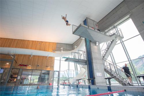 a person jumping off of a swimming pool at Villa Fjellheim in Luster