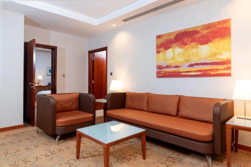 a living room with a couch and two chairs at Holiday Inn - Suites Kuwait Salmiya by IHG in Kuwait