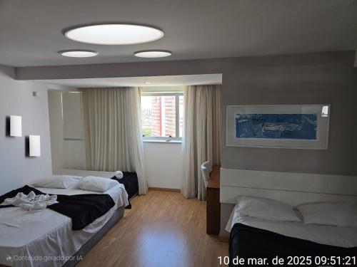 サルバドールにあるBahia salvador Business Flatsのベッドが2つと大きな窓がある寝室