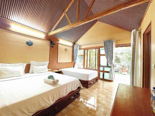 a bedroom with two beds and a large window at Tam Coc Hello Homestay in Ninh Binh