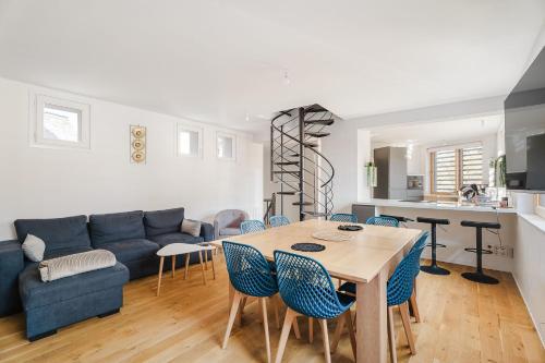 un salon avec une table et un canapé bleu dans l'établissement L’atelier, appartement lumineux et cosy, à Ploërmel