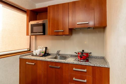 a kitchen with a sink and a microwave at Holiday Inn Kuwait by IHG in Kuwait