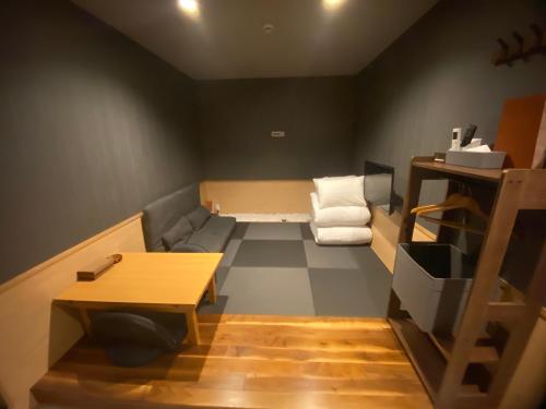 a small room with a couch and a chair at My Home Inn Sennan, Onosato in Ozaki