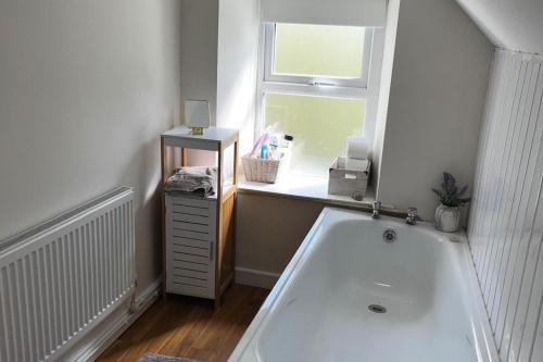 a bathroom with a bath tub and a window at 3br-Sea View-Fireplace-Garden-Free Parking in Falcarragh