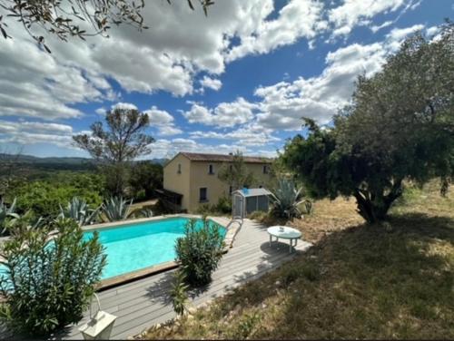 - une piscine sur une terrasse en bois à côté d'une maison dans l'établissement Les Frigoules des Hauts de Fabiargues, à Saint-Ambroix