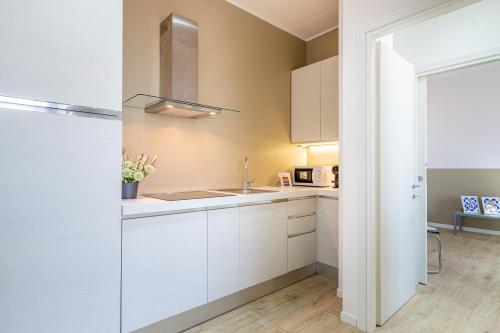 a kitchen with white cabinets and a sink at Il quadrato blu in Vimercate