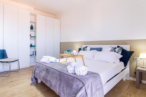 a bedroom with a bed with towels on a table at Il quadrato blu in Vimercate