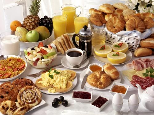 a table topped with lots of different types of breakfast foods at Blue Spring Hotel Wadduwa in Wadduwa