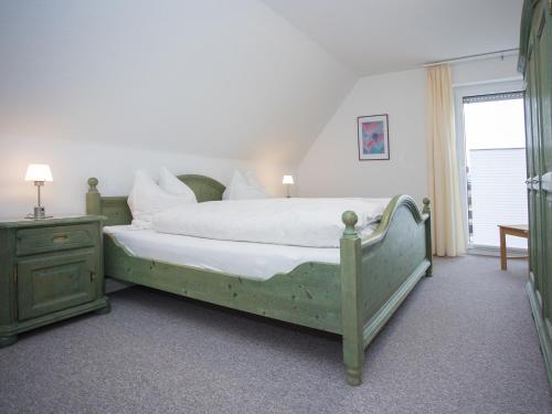 Un dormitorio con una cama verde y una ventana. en Welcome in - vakantiewoningen in Winterberg met panoramisch uitzicht, en Winterberg