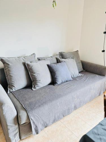 a gray couch with pillows in a living room at Appartamento con Vista Panoramica e Garage Ideale per Famiglie 4 Persone in Fiuggi