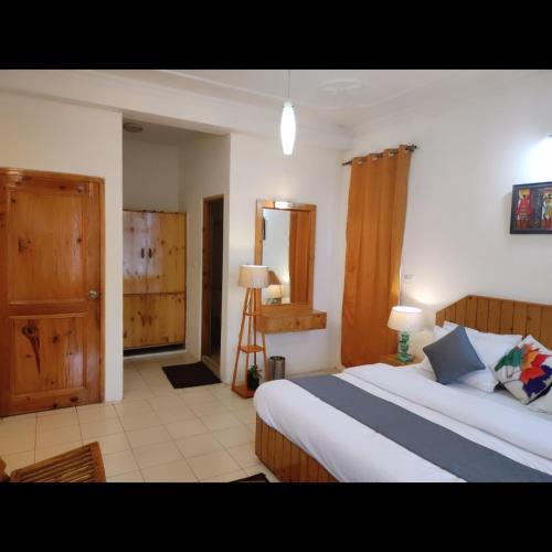 a bedroom with a large bed in a room at Cloud 9 wooden villa in Manāli