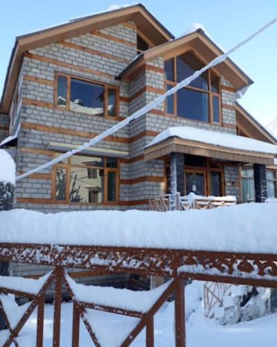 a log cabin in the snow with snow covered at Cloud 9 wooden villa in Manāli