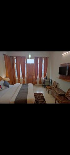 a bedroom with a large bed and a living room at Cloud 9 wooden villa in Manāli