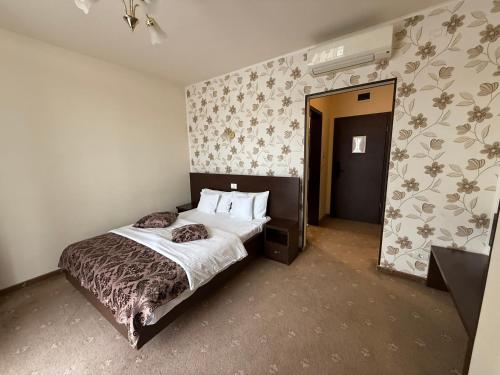 a bedroom with a bed and a wall with flowers at Hotel Miky in Arad