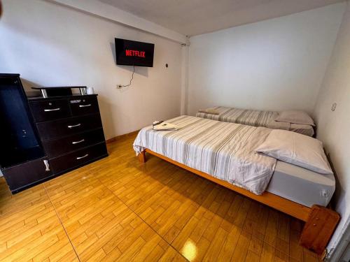 a bedroom with a bed and a dresser and a tv at Hotel Krammer en San Ramón, Selva Central in San Ramón